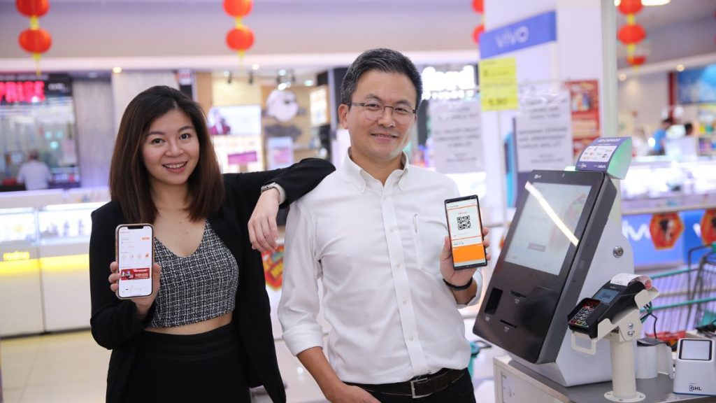 Truemoney spokespersons showing the app in Lotus's Malaysia